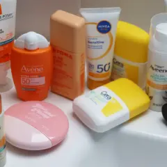 En samling solskyddsprodukter, inklusive krämer och serum, för att skydda även melaninrik hud.