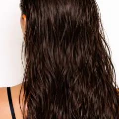 Mörkt, glansigt hår med en snygg wetlook-effekt. Håret faller i mjuka vågor över axlarna.
