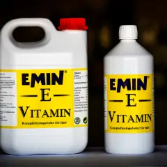 Två flaskor med hästfoder som innehåller vitamin E. Den större flaskan har ett rött lock, den mindre ett vitt.