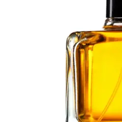 En flaska med gyllene parfym, som lovar en varm och sensuell amber doft.