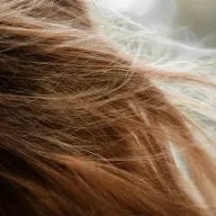 Närbild på brunt och blont hår som fladdrar, en påminnelse om håravfall under klimakteriet.