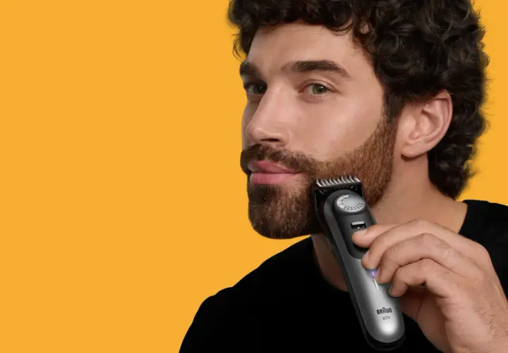 Man trimmar polisonger med en trimmer.