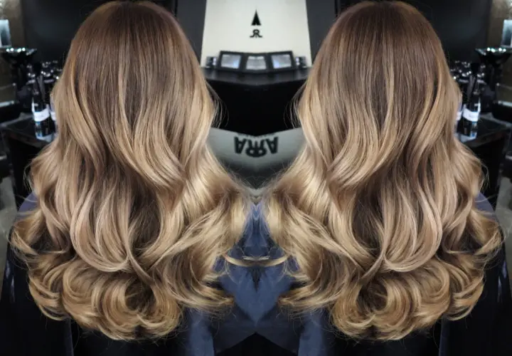 Vackert balayage ljust hår med mjuka vågor. En perfekt solkysst look.