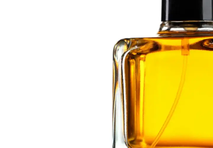 En flaska med gyllene parfym, som lovar en varm och sensuell amber doft.