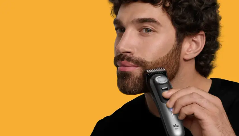 Man trimmar polisonger med en trimmer.
