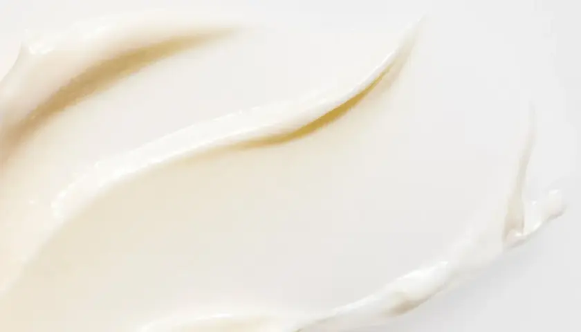 En krämig textur av vit hudvård med resveratrol, som ger näring och lyster.