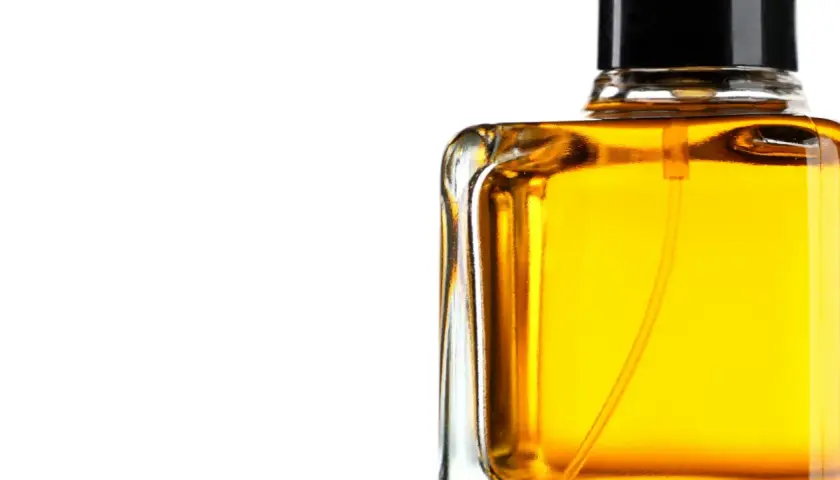 En flaska med gyllene parfym, som lovar en varm och sensuell amber doft.