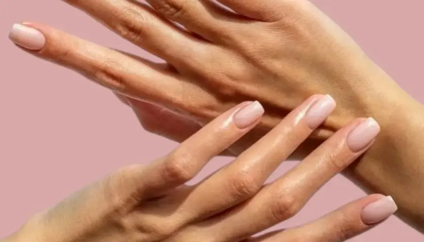 Två händer med ljusrosa naglar. Naglarna är välmanikyrerade, men nagelbanden är torra och behöver fukt.