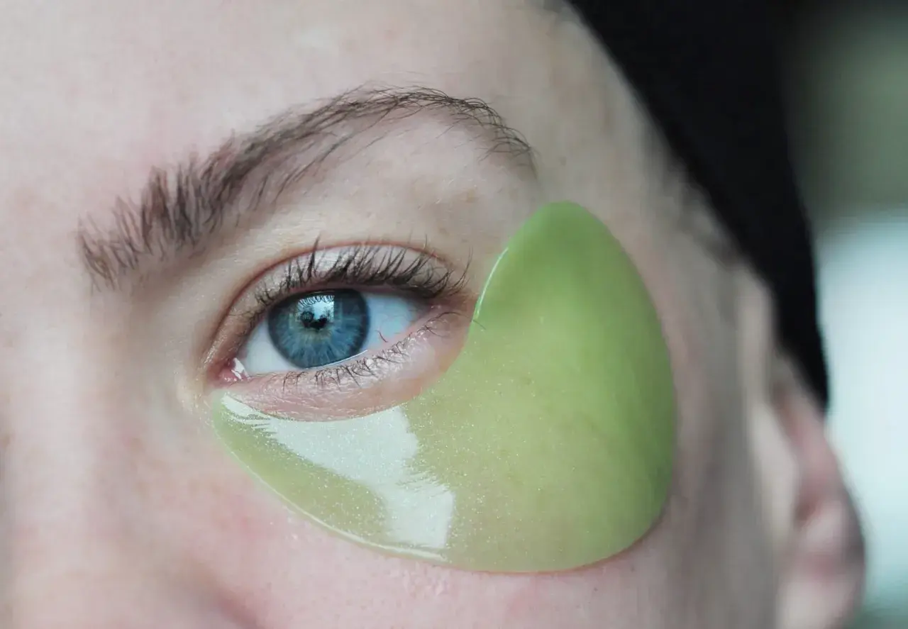 En ljusgrön eye patch sitter perfekt under ögat, följer hudens konturer. Visar hur eye patches ska sitta för maximal effekt.