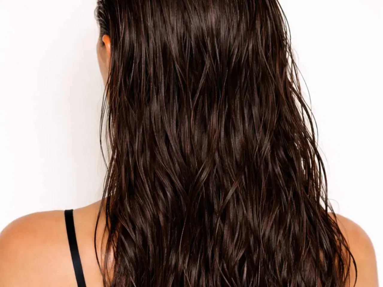 Mörkt, glansigt hår med en snygg wetlook-effekt. Håret faller i mjuka vågor över axlarna.