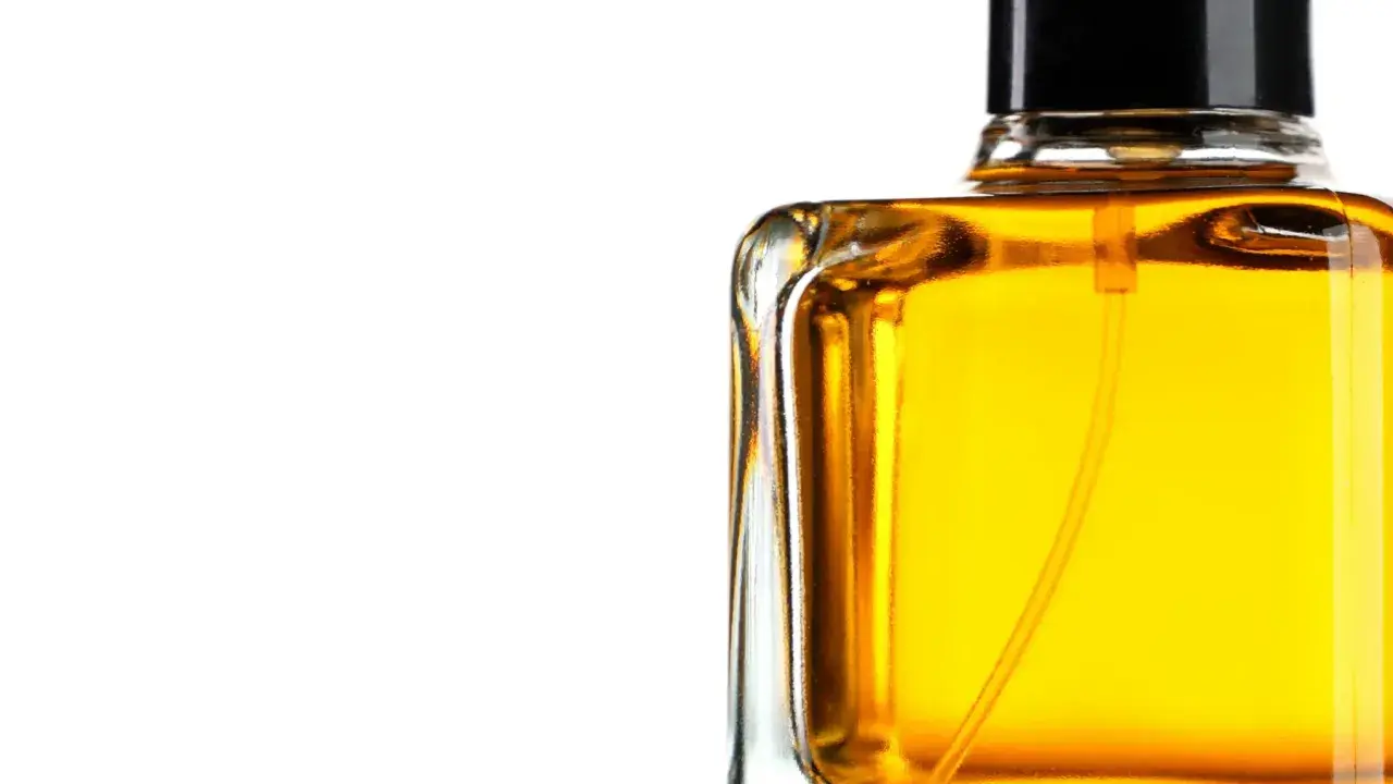 En flaska med gyllene parfym, som lovar en varm och sensuell amber doft.