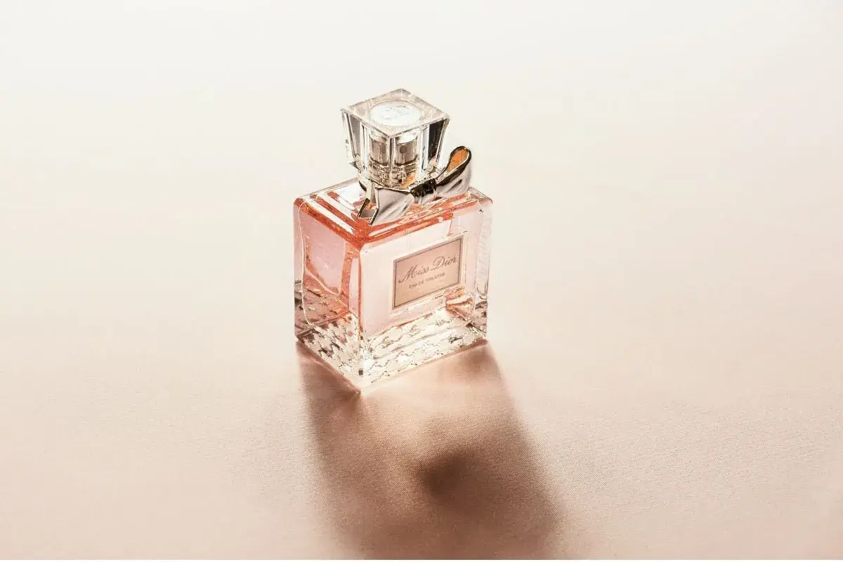 En flaska Miss Dior Eau de Toilette med en rosa vätska. Frågan om kan parfym bli gammal är relevant, men denna flaska ser fortfarande fräsch ut.